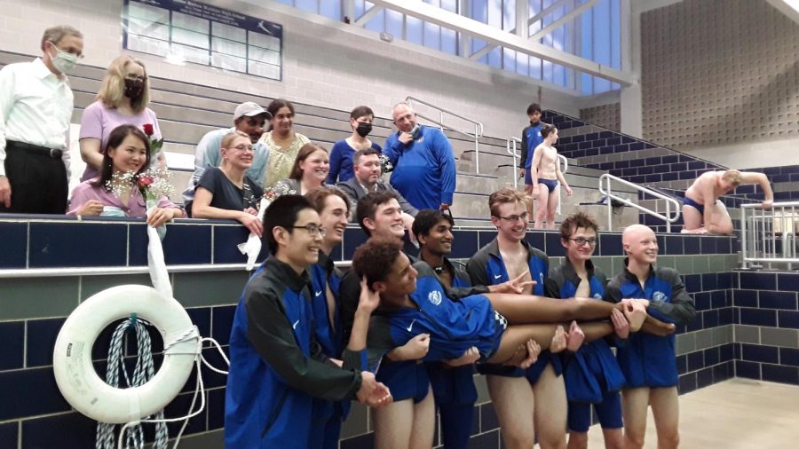 Swim and Dive seniors pose alongside their parents. From left to right: Anthony Wang, Maddoc McGowan, Grant Cox, Rohan Tatikonda, Ben King, Henry Naismith and Cade Vetter. Being held up is James Ramey. 