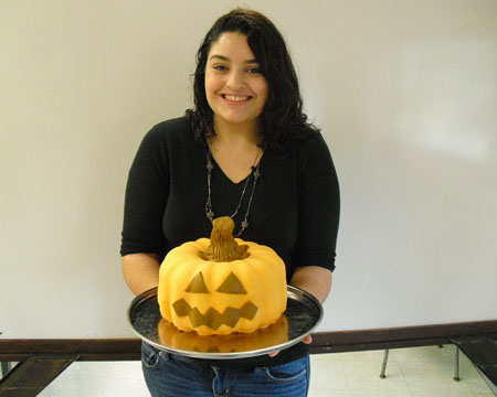 Kelly presents her final product: a pumpkin shaped cake with fondant decorations. Kelly baked her creating during her independent cooking course with practical arts teacher, Jill Svejkosky.