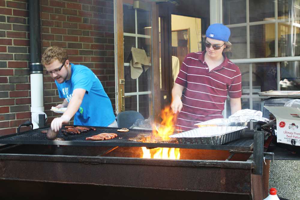 In the courtyard, seniors Andy Cohen and Steve White barbecue hamburgers and hotdogs, Sept. 7. As a celebration of reopening the Ram Shack, DECA held a barbecue during lunch.