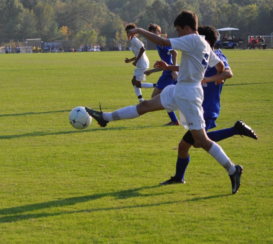 Freshman Grant Garland challenges the SLUH player for the ball. 