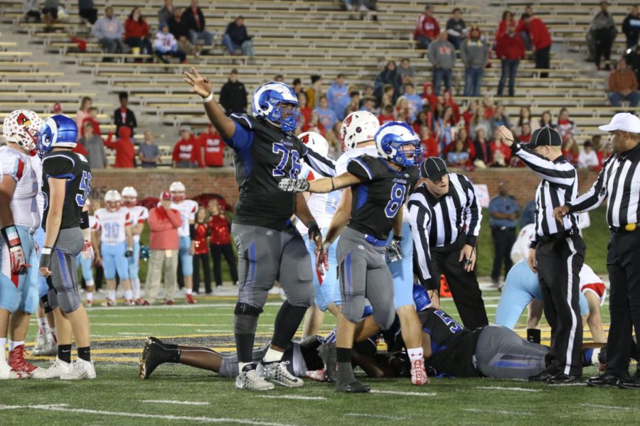 Senior Jaylen Sykes and junior Andrew Hunt signal that Ladue recovered the fumble. 