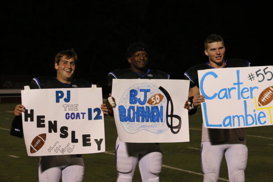 Seniors PJ Hensley, BJ Buchannon and Carter Lambie hold up their signs after the game against Windsor Oct. 20. 