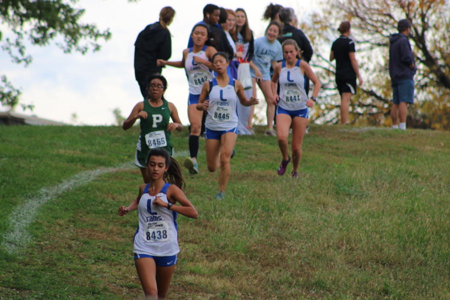 Sophomore Callie Cox and three of her teammates run down a hill during the district race. 