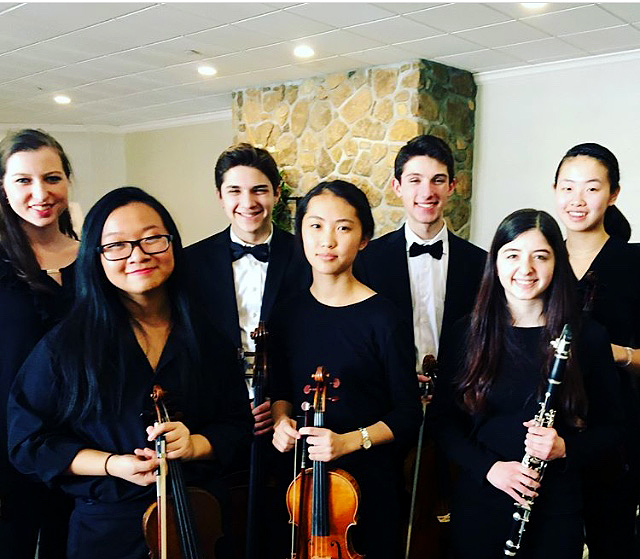 Post-concert smiles abound for Ladue All-State Orchestra members. Senior Grace Crockett, sophomore Anna Zhong, freshman Daniel Diringer, freshman Becky Lang, sophomore Jacob Sheldon, senior Evyn Levy and sophomore Shirley Pan pose Jan. 27. Not pictured is freshman and clarinetist Pema Childs, who played in the All-State Band. A funny part about All-State was that we got out of rehearsal an hour early once to see a sunset, but it was cloudy, so there was no sunset to see, Sheldon said.
