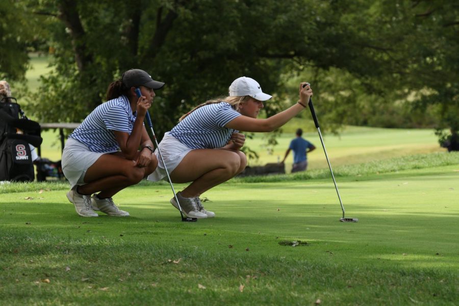 Senior Kacy Spratt and junior Meera Upadhyay look closely after a putt shot Sept. 24th 2021. Both Spratt and Upadhyay have been on varsity since freshman year. They played the match against Rockwood Summit.