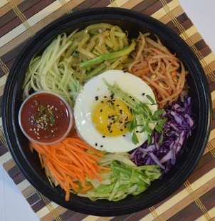 Shaking Bowls one-of-a-kind veggie bowl. This dish is made up of mung bean sprout, carrots, red cabbage, zucchini, cucumber and a sunny side up egg. For a vegan alternative, the egg can be substituted for tofu.