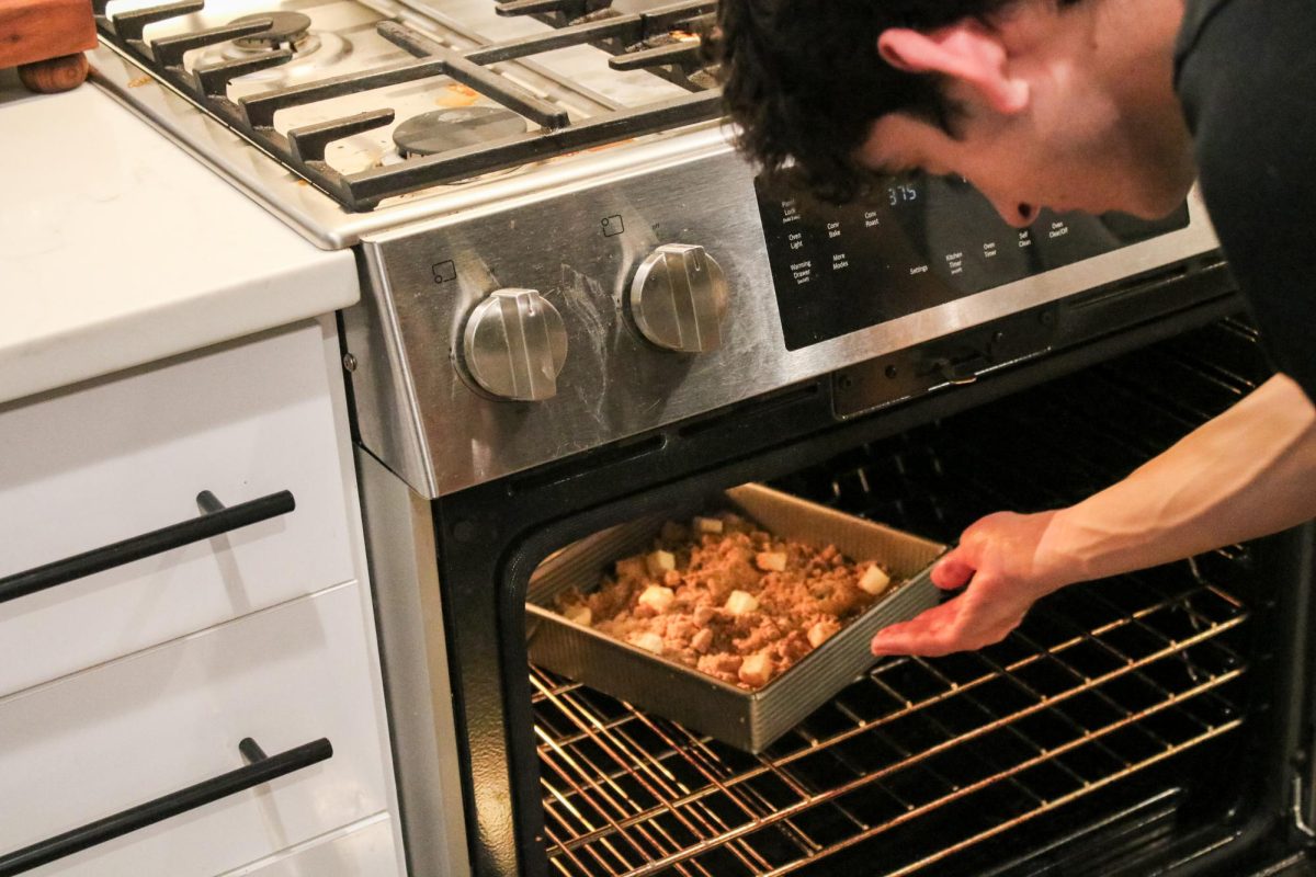 Tarek Al Husseini puts his bake-off apple crisp into the oven. He was attempting to recreate Macs version without the directions. The original crisp was flakey on the bottom, so I approached it like I would a pie crust, Al Husseini said.