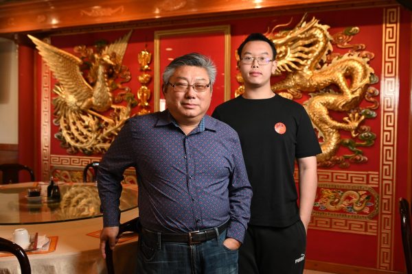 Co-owner Jerry Li stands next to his nephew Edison Lu in their family-owned restaurant LuLus Seafood and Dim Sum Oct. 5.  The two spent nearly every day together greeting customers, serving their famous Cantonese food, and maintaining the restaurant. The restaurant is a family business. The whole family is working together and contributing their skills to keep the restaurant alive, Lu said. 