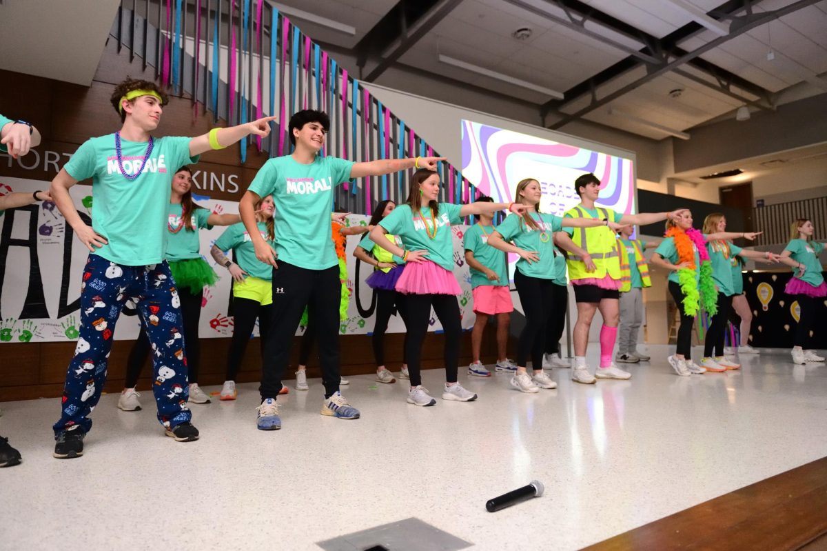 Members of Ladue Dance Marathon’s Morale team gather on the multipurpose room stage to present their dances during the main event Feb. 4, 2023. Morale taught participants a variety of dances each hour of the event. I enjoy being on Morale because we are dancing and having fun, but we are also raising money for the kids,” Will Minkler (10) said. “The best part of the event is listening to the kids stories and how we are helping them.” 