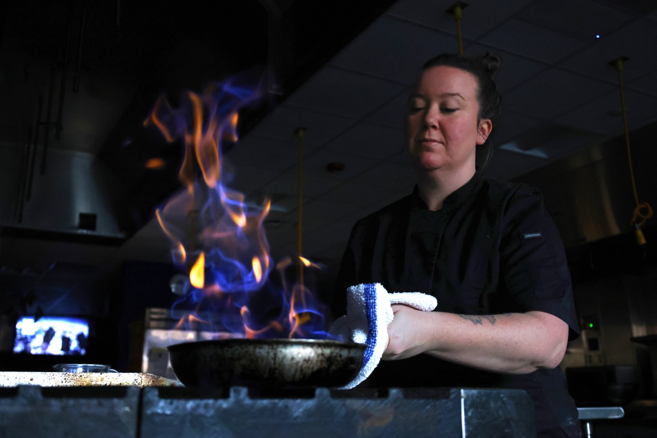 April Dalton cooks Bananas Foster, a dessert consisting of bananas sautéd in butter, sugar and cinnamon. The bananas were cooked over a fire with rum and served atop a scoop of vanilla ice cream. “[Cooking] is not just like reading a piece of paper and making it happen," Dalton said. "There's a lot more involved and I don't think people realize that when they get into the kitchens."