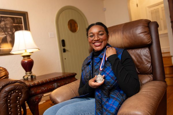 Gianna Francis (12) holds up her Congressional Award Gold Medal in her home Feb. 5. Francis won the award in January after four years of hard work and determination. “I finally got it,” Francis said. “Everything submitted. Everything’s in order. It was just a big sigh of relief.” 