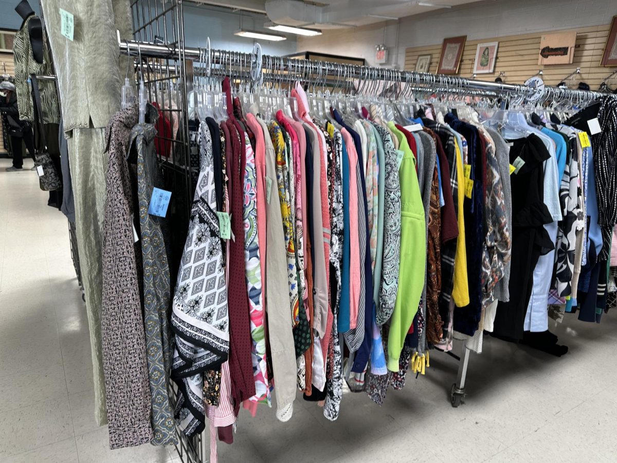 Clothing racks and shelves piled with other donations fill Society of Saint Vincent De Paul Thrift Store.