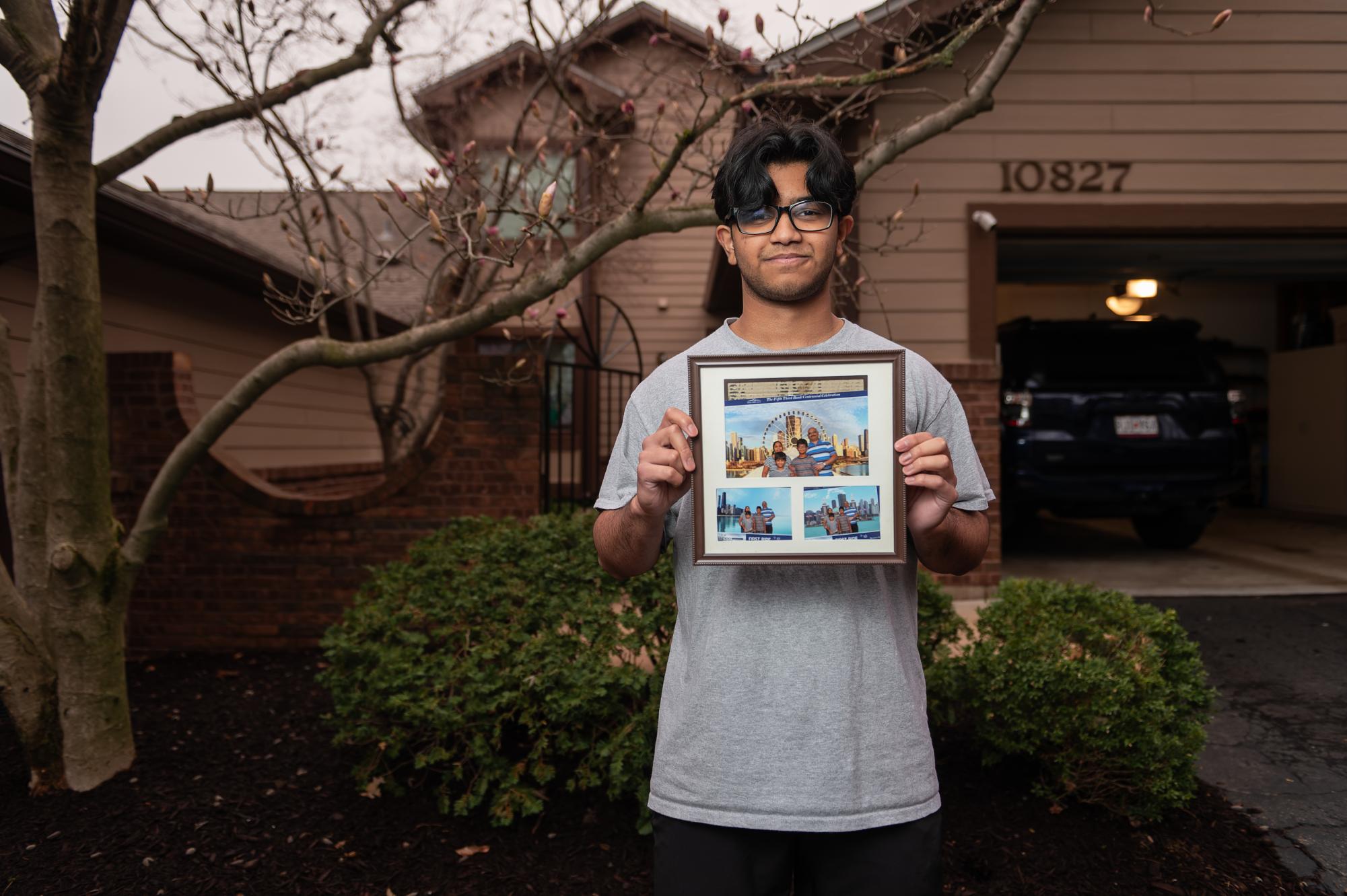 Junior Aneesh Patil displays photos of his family on a vacation in Chicago. His family reunited in the U.S. after being apart from his father for a year. “I didn't want to come to U.S. at the beginning [but my sons] were missing their dad,” his mother Anu said. “That was the reason I had to move here."