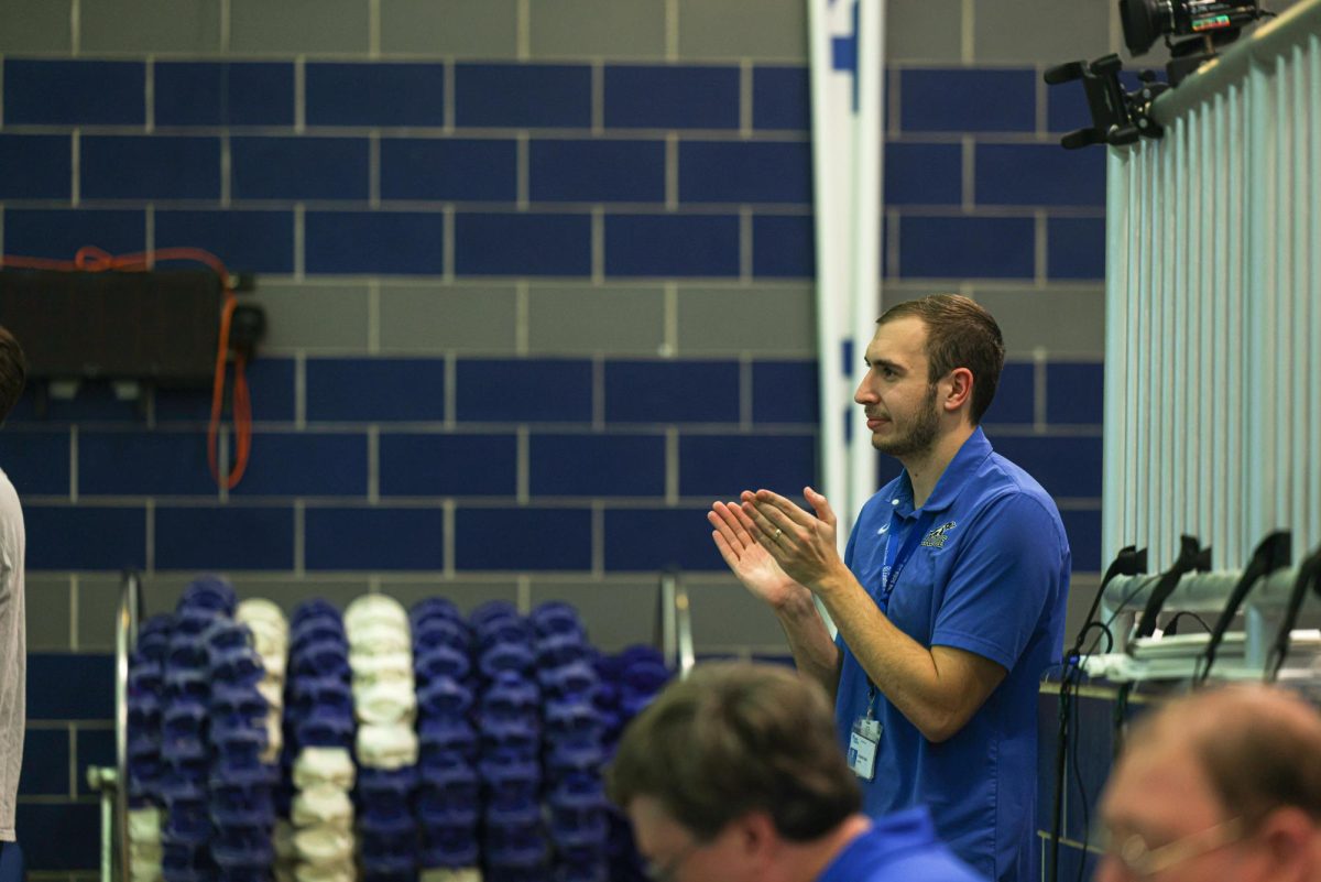 Water polo coach Jacob Jagodzinski claps while watching Ladues girls swim team compete at Senior Night. He enjoyed watching his players progress over the season. “Im a pretty patient person outside of the pool, in both my career and just my regular life. Jagodzinski said. But Im a lot more aggressive in water.”