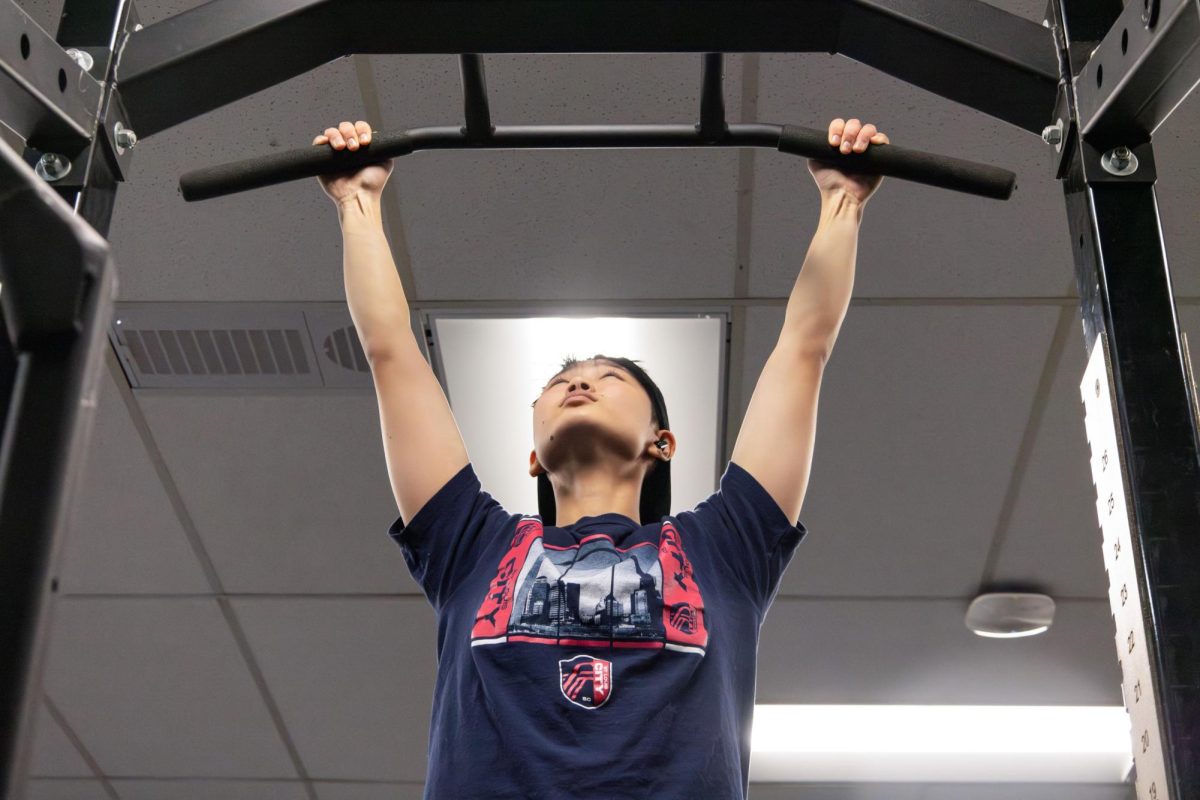 Seph Zhu (10) performs a pull up in the weight room Nov. 20. His favorite exercise to perform is the pull-up. “It is
definitely pull-ups, because I’m good at them, and I think they are pretty fun,” Zhu said. “Also there are a lot of progressions that you could do with pull-ups.”