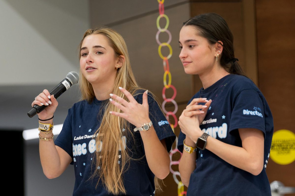 Georgia Bland (12) and Harper Buxner (12) stand on the stage managing the event. They had been preparing for the event since August and the last week has been the important in making the final touches for the event. "Then Friday night we began to set up and continued all day Saturday to make sure everything was ready from posters, streamers, and decorations, to food, raffle items and guests," Bland said.