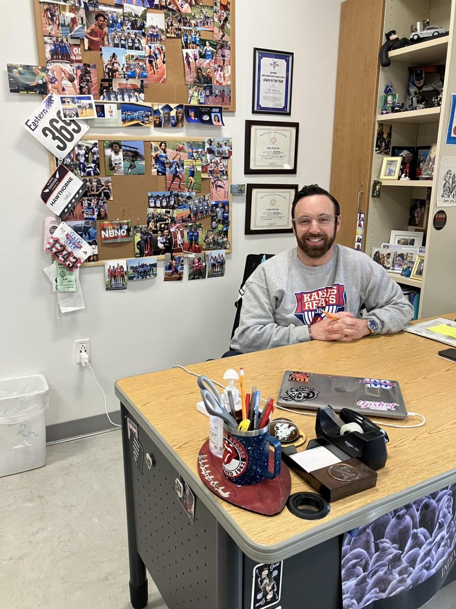 Buckvar sits behind his desk with a large variety of track memorabilia behind him.