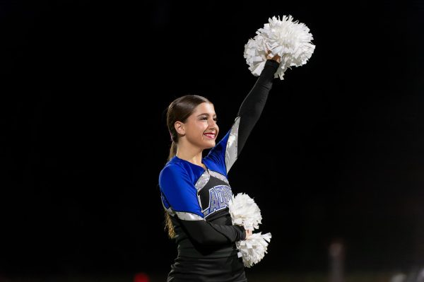 Mia Gourtzelis (11) cheers during a football game. Gourtzelis has been on the team since her freshman year. “I am so excited to debut the dances we have been working on for several months,” Gourtzelis said.